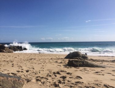 sandy-beach-and-rocks-and-crashing-waves.jpg